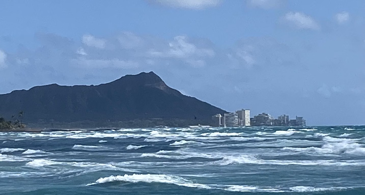 Diamond Head rising above the Waikīkī shoreline, seen across open water from the south shore of Oʻahu