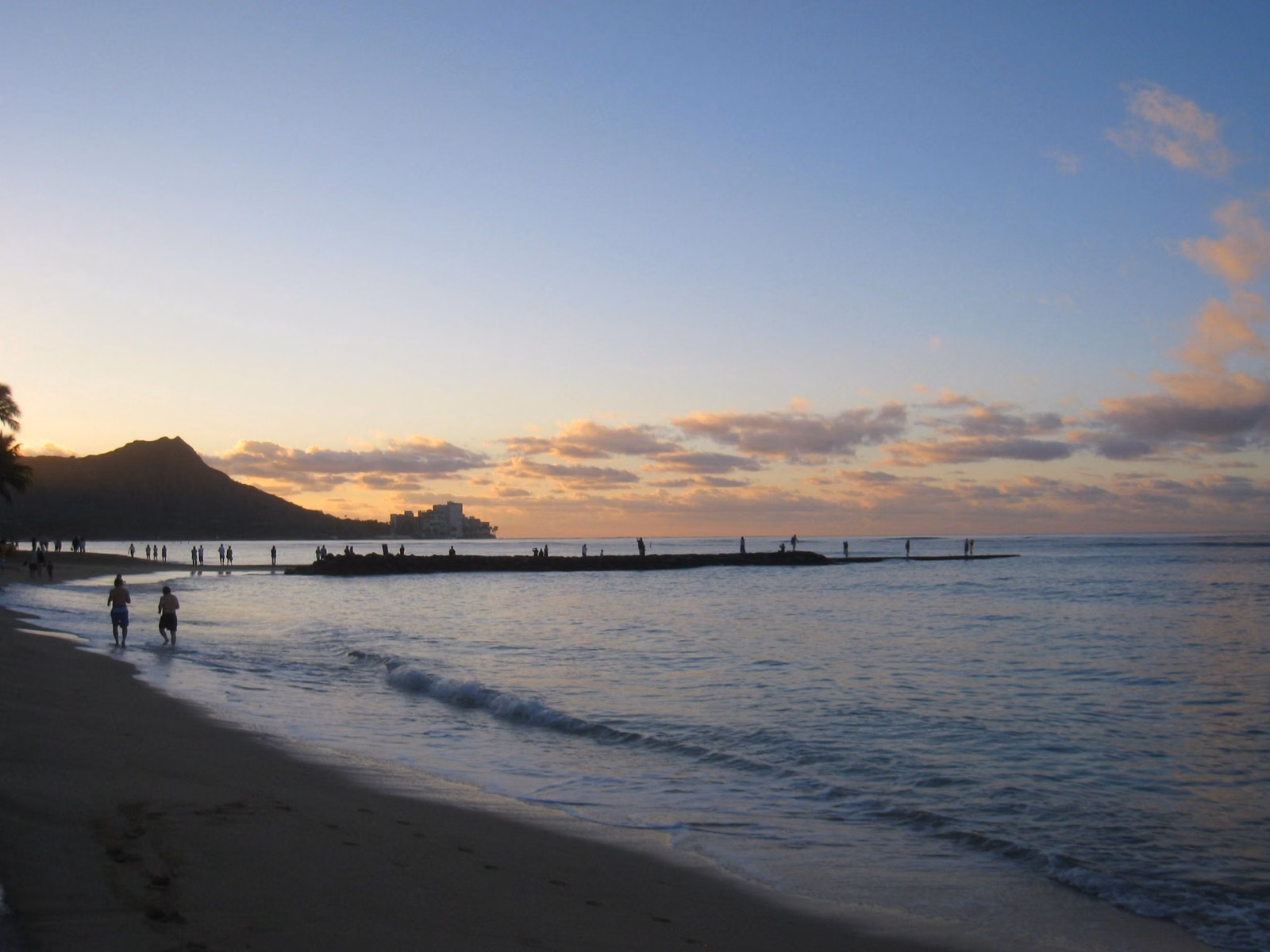 Diamond Head silhouetted at dusk across the water from Waikīkī Beach